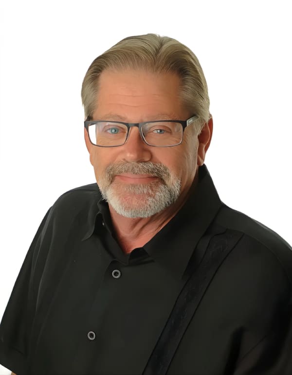 A man with glasses and beard wearing a black shirt.